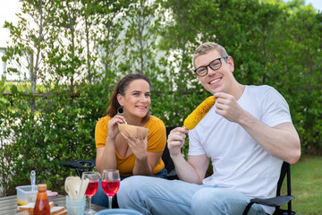 Fototapeta premium Happy family having barbecue, bbq, party with red wine in outdoor backyard garden of house with happy meal on summer holiday weekend