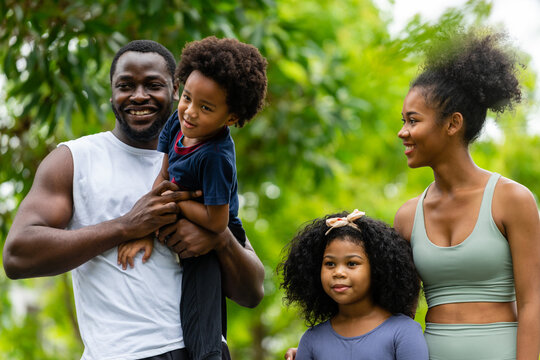 A Family Of Black Americans And Their Son And Daughter In Sportswear Line Up To Take Pictures, Smiling Cheerfully At The Camera.