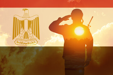 Double exposure of silhouette of a solider and the sunset or the sunrise against flag of Egypt....