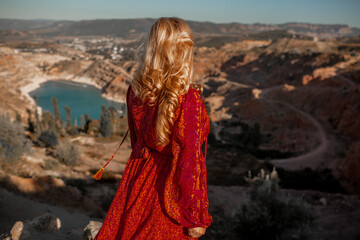 Plus size woman with beautiful blond hair , wearing red boho style clothes enjoy the time in nature against blue water of lake