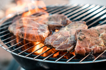 Steak auf einem Holzkohlegrill mit Flammen