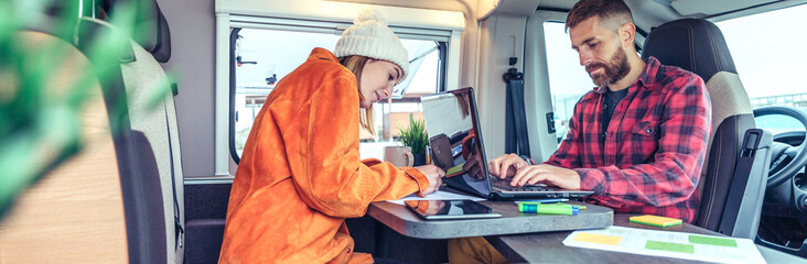 Young woman and man telecommuting during a camper van trip