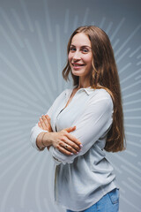 Young long-haired woman in jeans and a white shirt on a plain background. Emotions on a woman's face