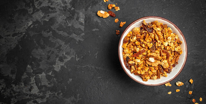Bowl with granola on a dark background. superfood concept. Healthy, clean eating. Vegan or gluten free diet. Long banner format. top view