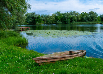 boat moored near the river bank, wooden fishing boat in the village