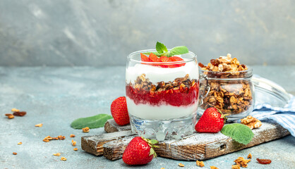 Parfait with fresh fruit, greek yogurt, oat granola, honey and mint leaves in glass jar on a wooden board. gluten free diet, Healthy breakfast. place for text, top view