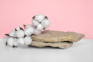 Stone Podium for promotion on pink Background. Natural pedestal. Rock. Beauty product mockup. Scene to show products. Showcase, display case. Front View, soft shadow. Cotton flowers branch