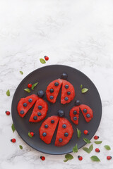 Slices of watermelon shaped like ladybugs, creative fruit for kids