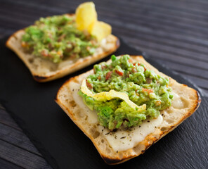 toasted slices of square bread with warm cheese and homemade guacamole on plate for healthy breakfast