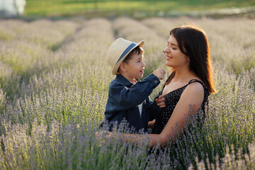 Mother and son have fun in lavender field during sunset walk