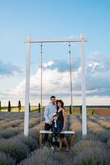 Family on a swing in a lavender field