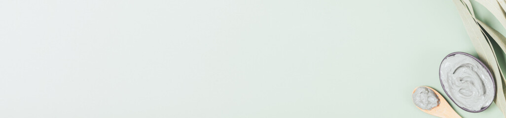 Green clay powder next to prepared cleansing face mask