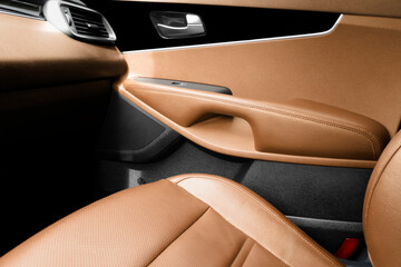 Modern luxury car brown leather interior. Part of brown perforated leather car seat details with...
