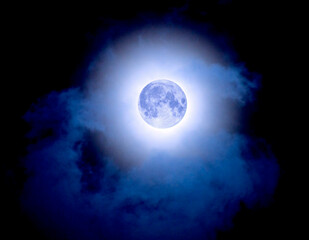 Fototapeta na wymiar Blue full moon in cloudy sky. June 13, 2022