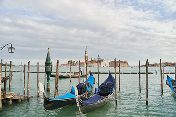 Fototapeta na wymiar Blue gondolas parked in the Venetian lagoon, the Grand Canal in Venice, Italy