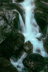 Long exposure photograph of a waterfall surrounded by big rocks