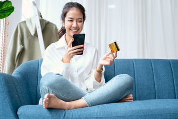 Young beauty Asian woman shopping payment online with credit card on smartphone at home