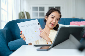 Young Asian business woman holding document meeting with team by video conference discuss online.