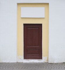 Brown wooden false door in a yellow-white wall