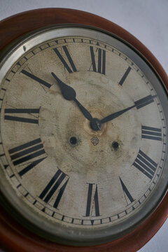 Details of an old clock on white wall