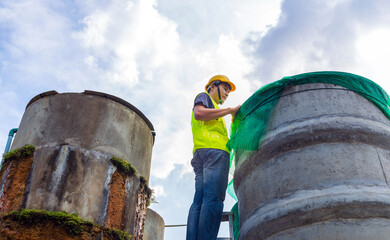 engineer controlling the quality of water Stand on the risky stairs at high places operating...