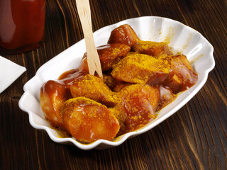 Currywurst mit Ketchup Flasche und Holzgabel