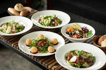 several different fresh salad dishes on restaurant table