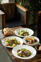 several different fresh salad dishes on restaurant table