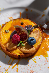 Pumpkin porridge in bread with blueberries, figs, cookies, seeds, flowers, and apricot pieces