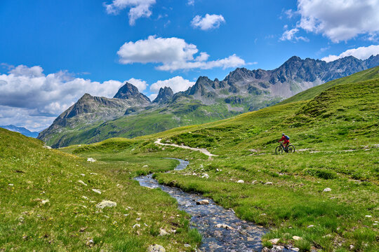 nice active senior woman riding her electric mountain bike in the silvretta mountain range above barrier lake Kopssee,near Gaschurn, Tyrol, Austria