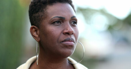 Pensive African woman thinking. Contemplative black lady in deep think outside