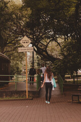 young woman backwards walking to catch the tram