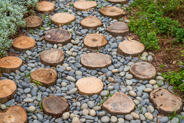 Walkway made of logs and pebbles in a landscaped garden