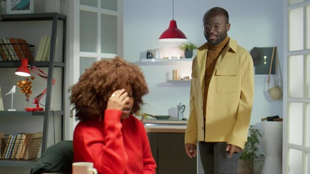 Abusive African American man shouting at his wife while having emotional quarrel at home