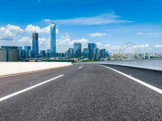 Asphalt road and city skyline with modern building in Suzhou, China.