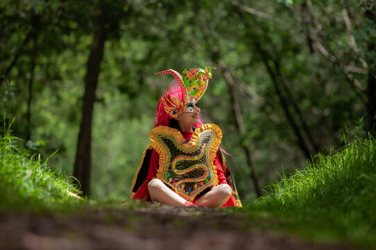 hispanic woman, Bolivian, sitting in diablada pillare&ntilde;a costume in the middle of the forest
