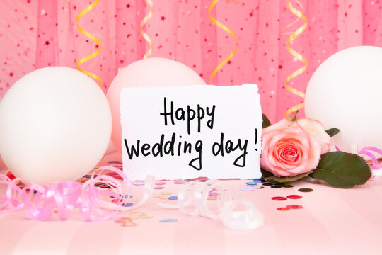 Happy wedding day - card and rose flower on pink background with air balloons and decorations