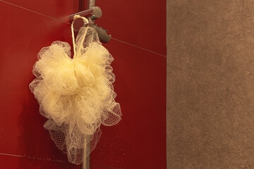 A washcloth for body care hangs in the bathroom with red walls.