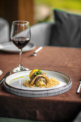 Gourmet restaurant fish dish with couscous and red wine