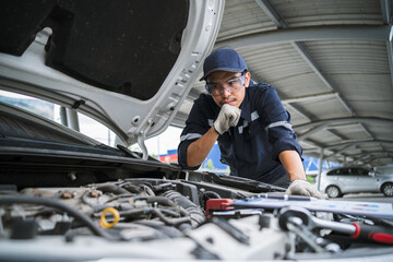 Auto mechanic service concept. Auto mechanic checking the safety and maintenance of the car in the garage. Repair service concept.