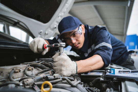 A uniformed maintenance technician is working on a vehicle inspection service. Vehicle repair and maintenance concept.