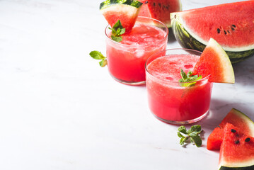 Fresh watermelon juice with mint and ice in the glass on white table.Sweet summer dessert, smoothie, cocktail healthy food concept, close up. Summertime. Copy spase. Selective focus