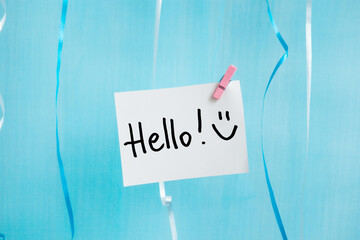 Hello - card with greeting text and smiley face on light blue background © justesfir