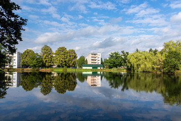 Obraz premium Building and trees reflected from the pond