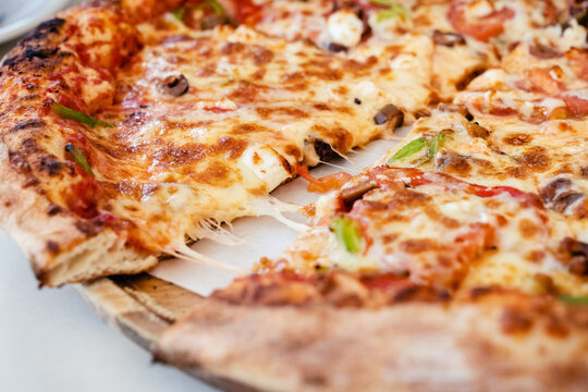 Greek pizza in outdoor restaurant. Tourist dinner in Agios Nikolaos in Crete, Greece. Summer vacation concept.