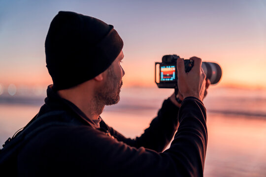 photographer taking pictures on the beach at sunset or blue hour