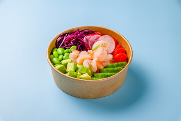 Poke with shrimps, avocado,edamame, cabbage, tomatoes and cucumbers on blue background
