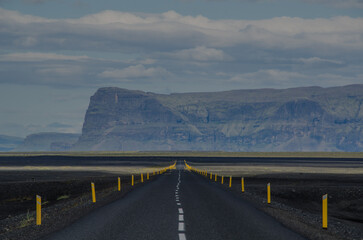 Lange gerade und befestigte Straße auf Island, Im Hintergrund ein Tafelberg