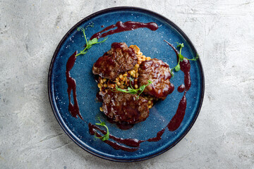 medallions of beef with perlotto on grey table