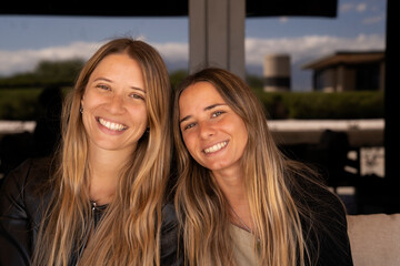 Family and friendship. Casual portrait of two sisters smiling at camera. 